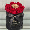 Red roses and a gold rose in a black hatbox with a ribbon