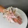 White orchid wrist corsage with a pink ribbon