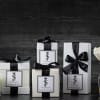 Gift boxes, a candle, and white flower stems in a glass vase