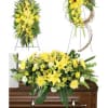 Yellow floral funeral arrangements displayed on a casket and easels