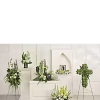 White floral funeral arrangements on stands and pedestals in a chapel setting