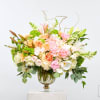 Large pastel floral arrangement in a glass vase