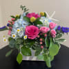 Blue Hydrandgeas, pink roses, hypericum, craspedia, purple statice, chamomile and mixed greens