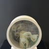 Memorial candle display with white calla lilies and a remembrance message