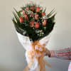 Bouquet of coral roses with baby's breath and a large ribbon