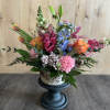 Colorful mixed flower arrangement in a pedestal vase