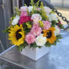 Mixed bouquet with sunflowers, pink roses, and carnations in a white box
