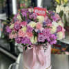 Pink and lavender rose bouquet in a round gift box with a ribbon