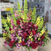 Basket arrangement of red roses, purple orchids, and green snapdragons