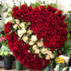 Heart-shaped arrangement of red and white roses on a stand