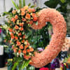 Heart-shaped floral wreath with peach roses and pink carnations