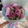 Bouquet of pink and lavender roses with small white filler flowers