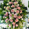 Large standing spray of pink roses and white blooms with greenery