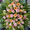 Pink roses and peach gerbera daisies in a large standing arrangement