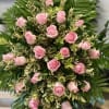 Pink roses arranged in a dense standing spray with variegated foliage