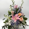 A soft &amp; elegant garden-style arrangement featuring pink lilies, blush peach roses
