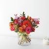 Mixed bouquet of roses, gerbera daisies, and carnations in a clear glass vase