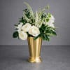 White flowers arranged in a gold vase with green foliage