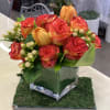 A compact cluster of orange-and-red roses creates a warm, celebratory focal point-perfect