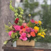 A lively, garden-style flower arrangement built around lush roses and ranunculus-perfect as