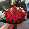 Bouquet of red roses with white baby's breath in black wrap