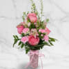 Arranged in a patterned pink ceramic vase and finished with a satin