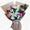 Bouquet of pink and white flowers wrapped in brown paper with a pink ribbon