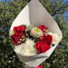 Bouquet of red roses, red carnations, and white chrysanthemums in white paper