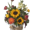 Mixed bouquet with sunflowers, roses, and tulips in a rustic wooden box