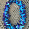 Blue and purple flower lei on a woven chair