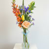 A tall, airy bud vase arrangement that brings a fresh, garden-picked feel