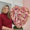 Heart-shaped pink floral arrangement with a ribbon bow