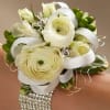 White ranunculus and spray roses are brought together with green hypericum berries