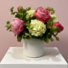 A modern, elegant arrangement featuring lush peonies, mini hydrangeas, and refined greenery.