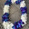 A floral lei made of white and blue-purple orchid blossoms