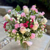 Pink and cream bouquet with roses and carnations in a glass vase