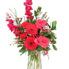Pink and red mixed flower arrangement in a clear glass vase