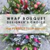Wrapped bouquet of pink tulips with mixed greenery and small purple flowers