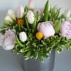 Pink and white tulips with pale peonies in a gray vase