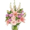 Pink lilies and roses in a clear glass vase