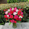 Pink roses and red carnations arranged in a glass vase