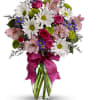 Bouquet of daisies, roses, and pink lilies in a glass vase