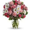 Mixed pink and white flowers arranged in a clear glass vase