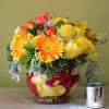 Orange Gerbera daisy, orange roses, yellow astromerias, dusty miller and yellow roses