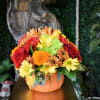 pumpkin ceramic fill with orange lily's, red carnations and buttons mums, red