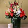 Tall glass cylinder vase with red tulips,white astromerias hot orange roses, curly