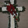 sympathy cross with white carnations and a cluster in middle of red