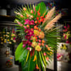 An abstract standing spray with roses,lilies,hydrangeas,Cala lilies, gladiolus,tropical leaves.

***Please note pompas grass