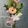 Mixed bouquet in a glass vase with pink roses, a peach gerbera, and white lilies