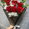 Bouquet of red roses with white baby's breath in black wrap
